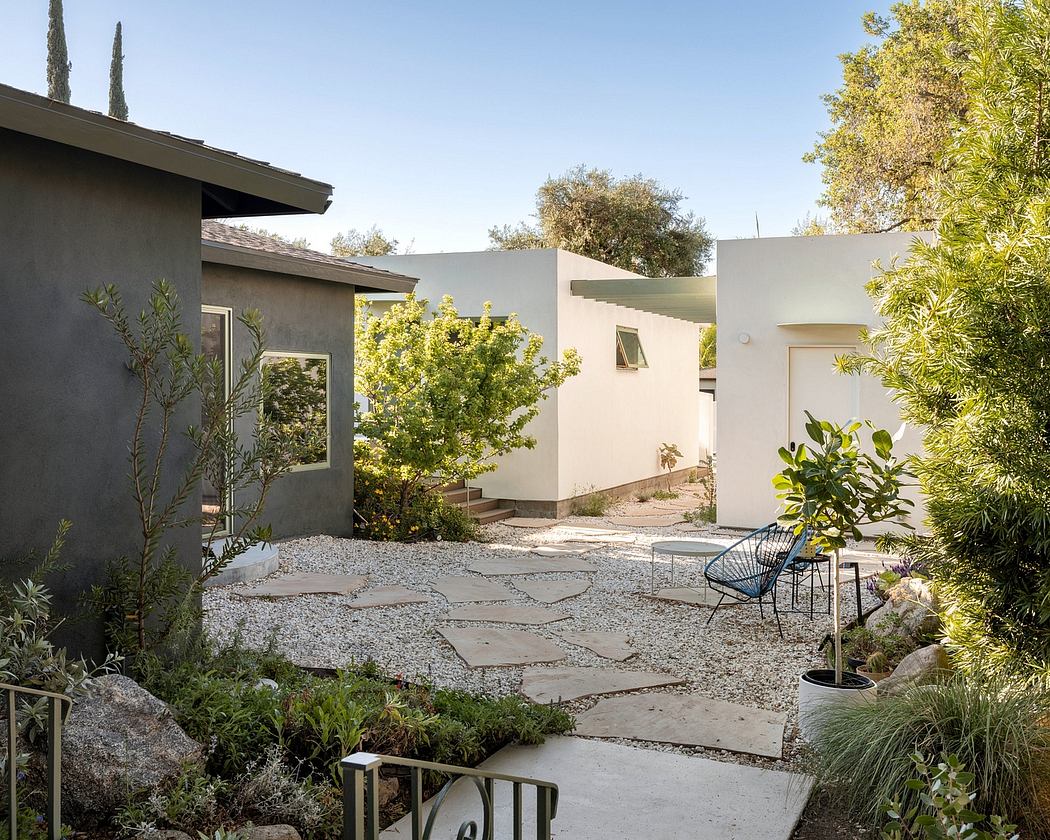Sleek, modern architecture with lush, landscaped courtyard featuring paved paths and seating.