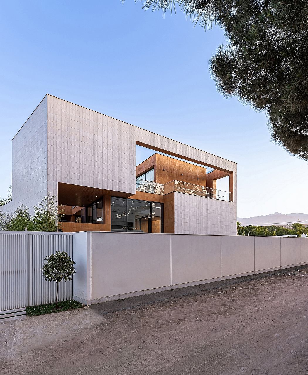 Modern, geometric facade with wooden accents and balcony overlooking scenic landscape.