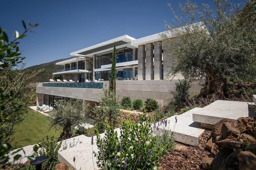 A modern, multi-level villa with clean lines, large windows, and a landscaped garden.
