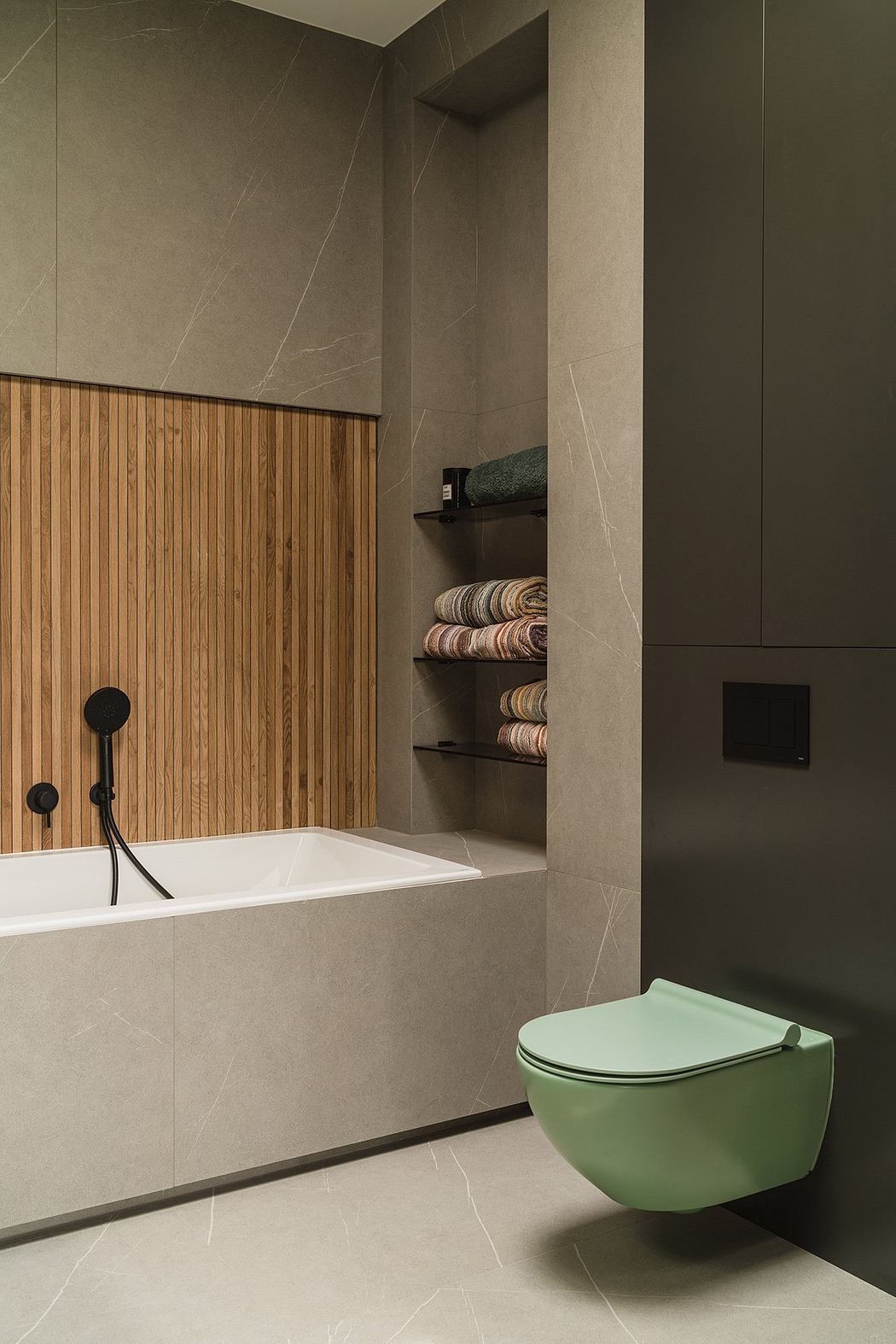 A modern bathroom with a minimalist design, featuring a white bathtub, wooden paneling, and a green toilet.
