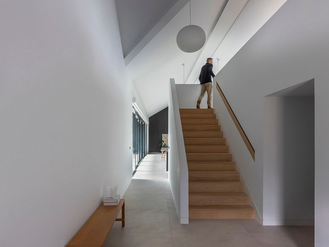 Modern staircase with wooden steps leading to an upper level, accented by minimalist decor.
