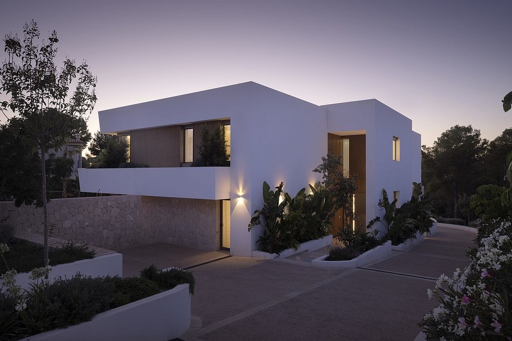 A modern, minimalist house with clean lines, warm lighting, and lush landscaping.