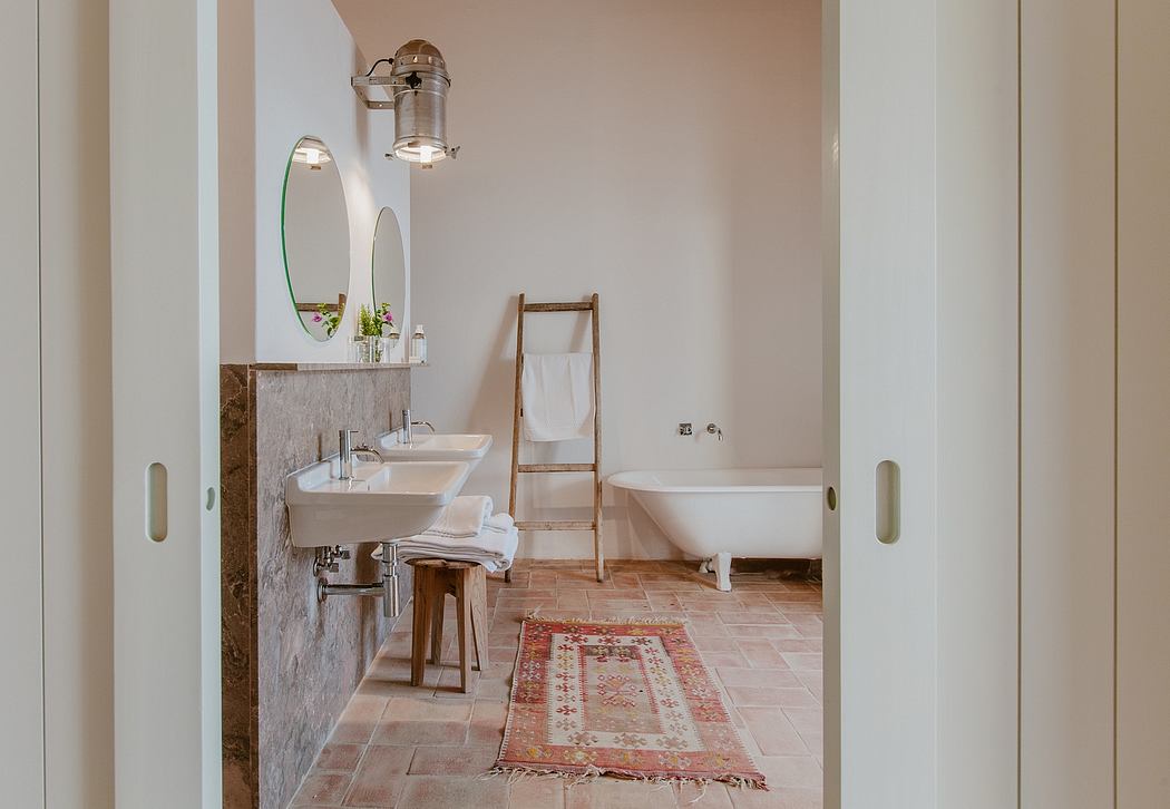 A cozy bathroom with rustic wood accents, a clawfoot tub, and a vintage-inspired rug.