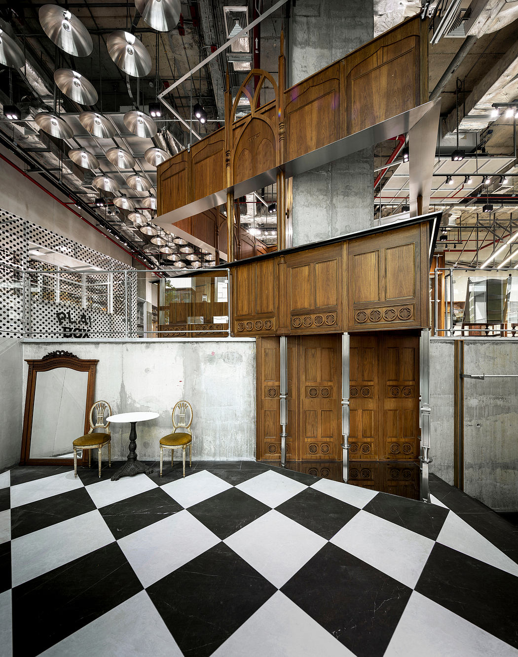 An eclectic mix of modern and vintage elements, with ornate wooden doors, checkerboard flooring, and industrial lighting.