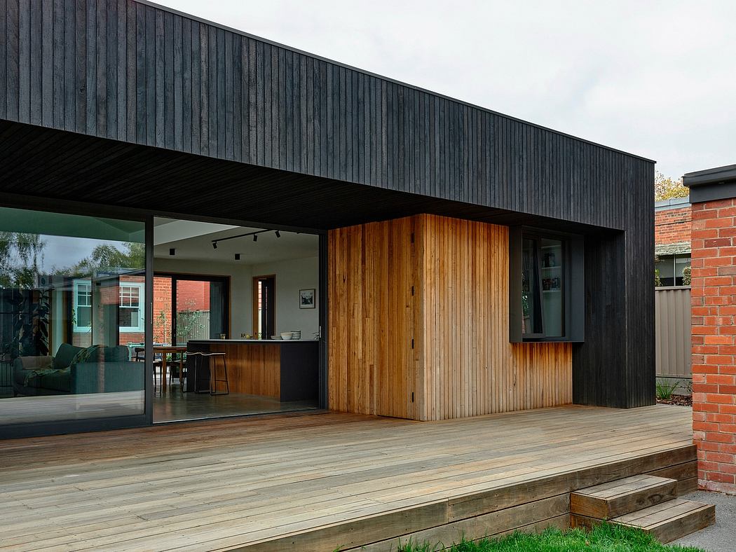 Sleek, modern design featuring contrasting wood and black exterior with large glass windows.