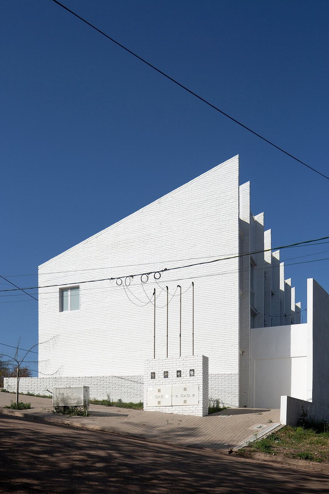 A striking white building with bold geometric shapes and clean lines against a blue sky.