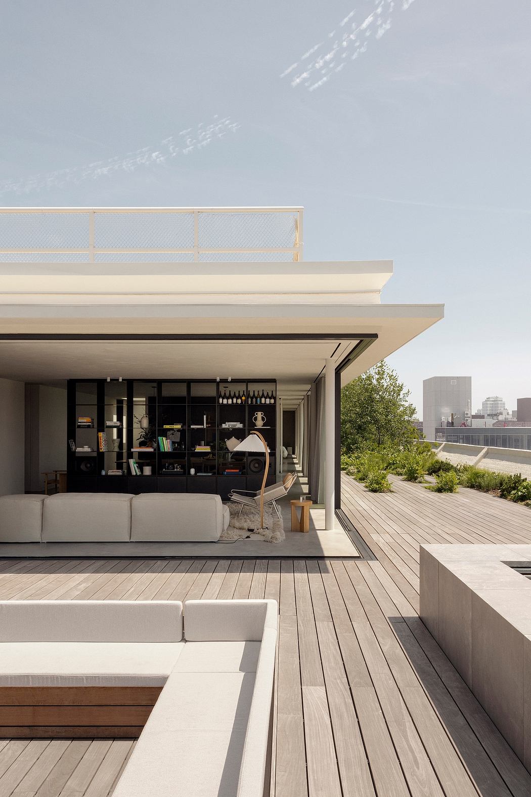 Modern, open-plan living space with expansive terrace, sleek furnishings, and cityscape view.