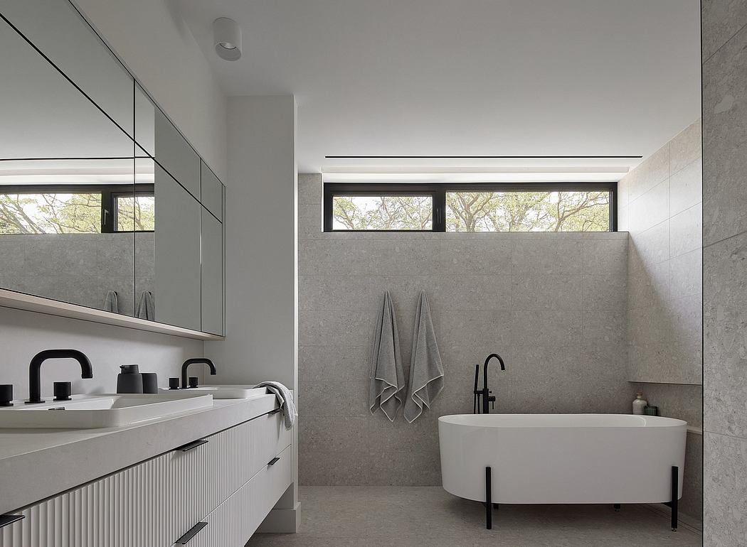A sleek, modern bathroom with concrete walls, minimalist vanity, and freestanding tub.