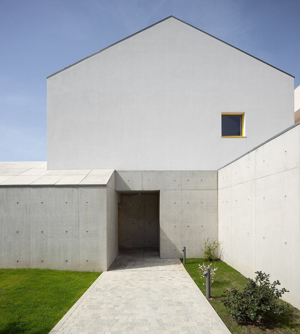 Minimalist architectural design with clean lines, concrete, and a single yellow window.
