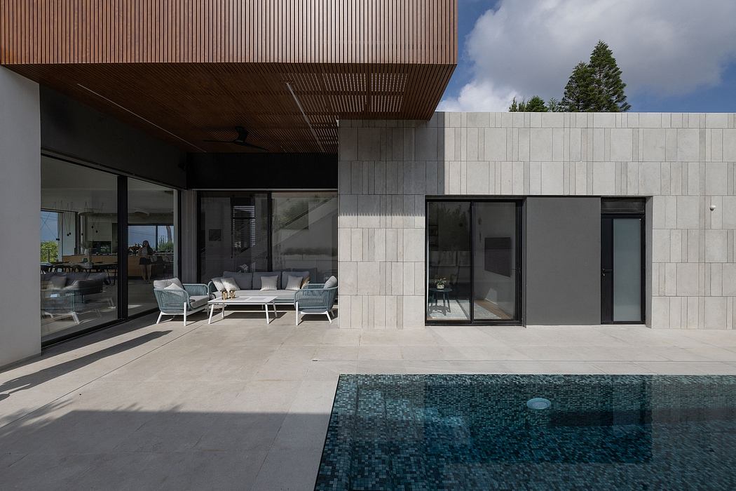 Modern, minimalist architecture with wooden panels, stone tiles, and a sleek pool.