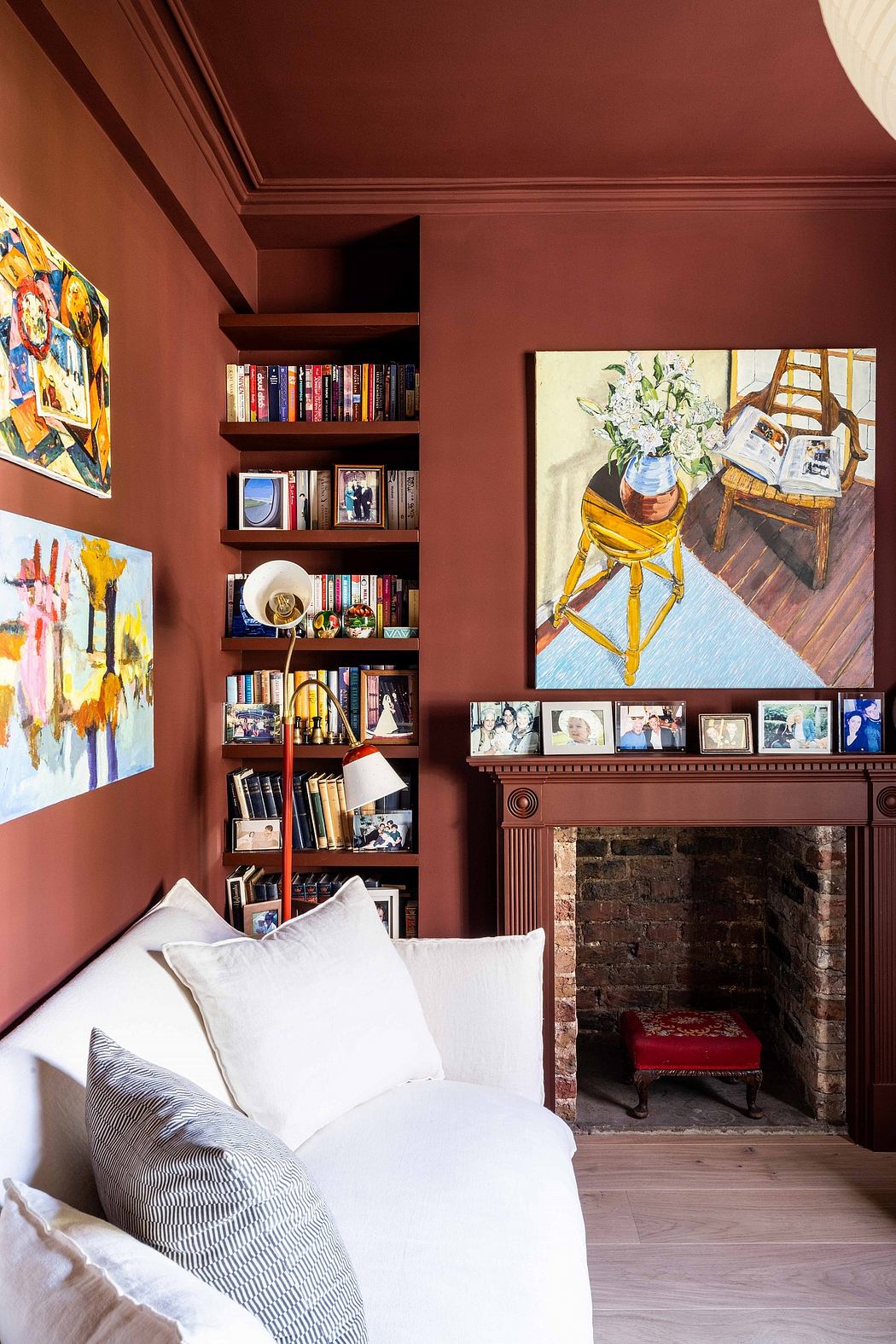 Cozy living room with brick fireplace, built-in shelves, and vibrant artwork.