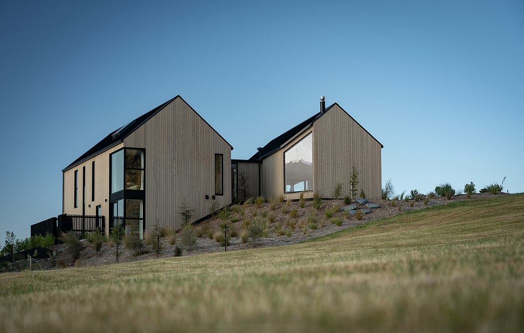 Modern hillside homes with angular wood-paneled exteriors and large windows.