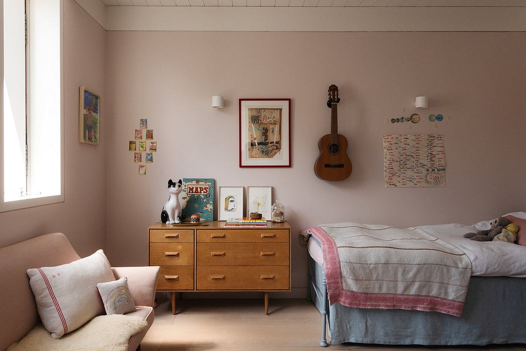 Cozy bedroom with mid-century dresser, guitar, and eclectic wall decor.