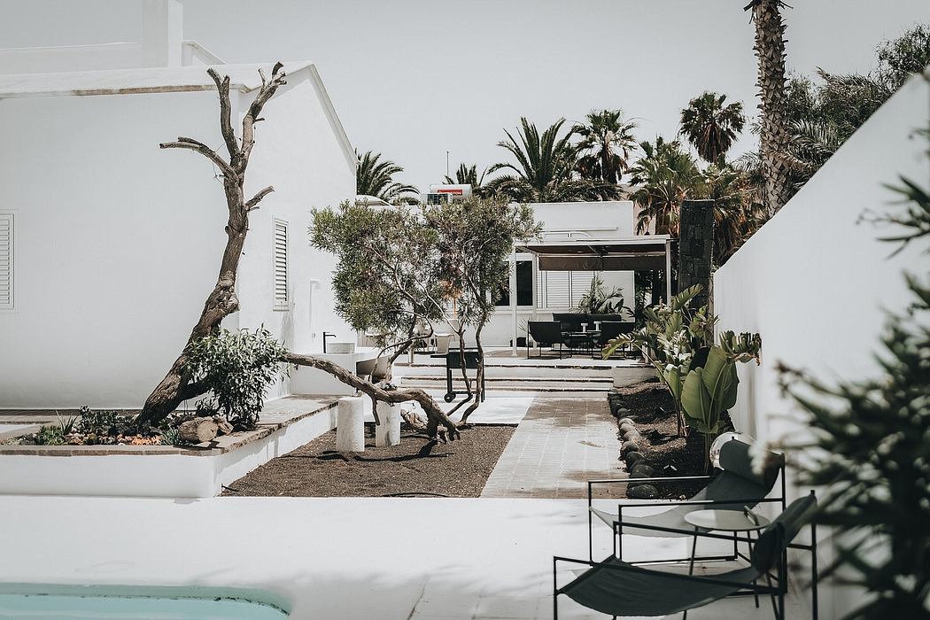 Striking modern architecture with lush tropical landscaping and seating areas.