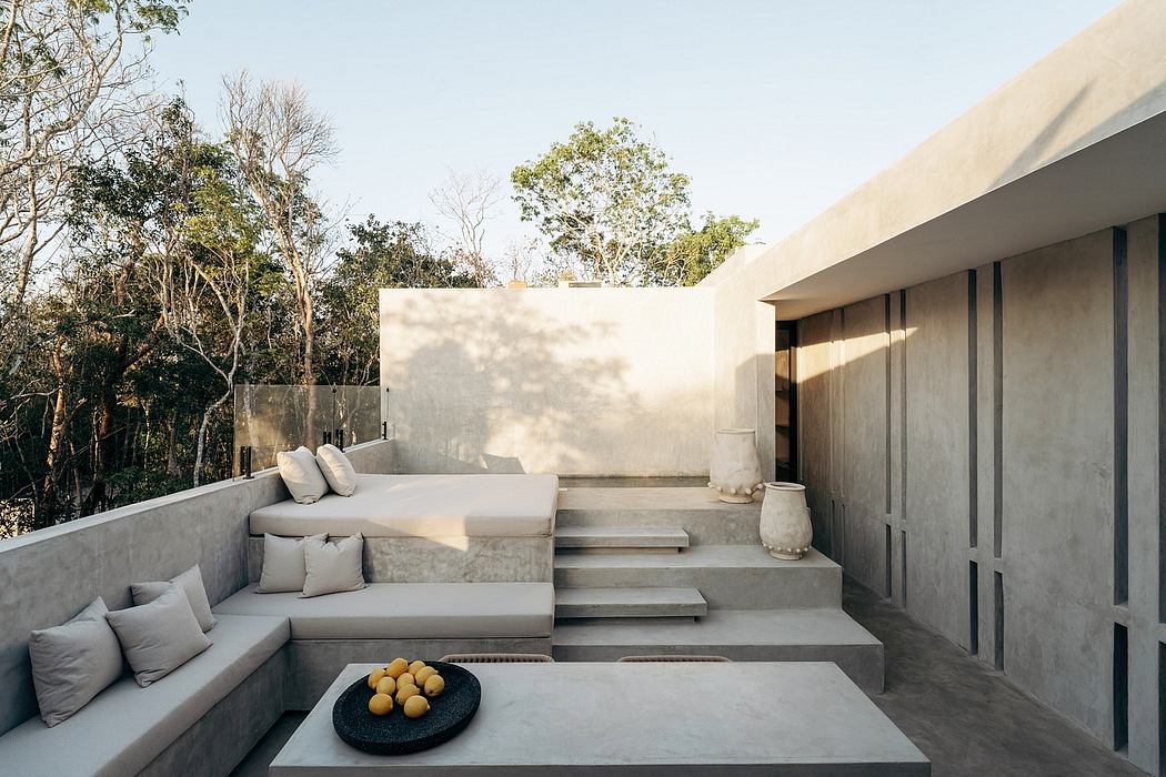 Serene outdoor seating area with concrete steps, plush cushions, and a bowl of lemons.