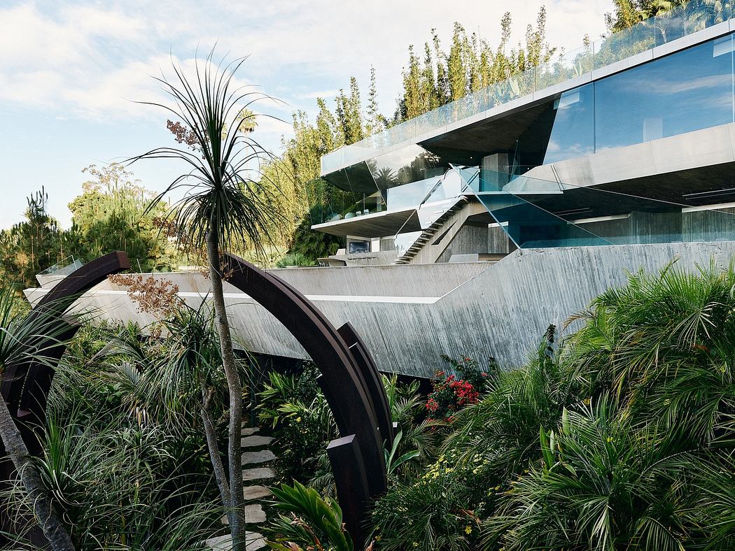 Striking modern architectural design with glass, concrete, and lush vegetation elements.