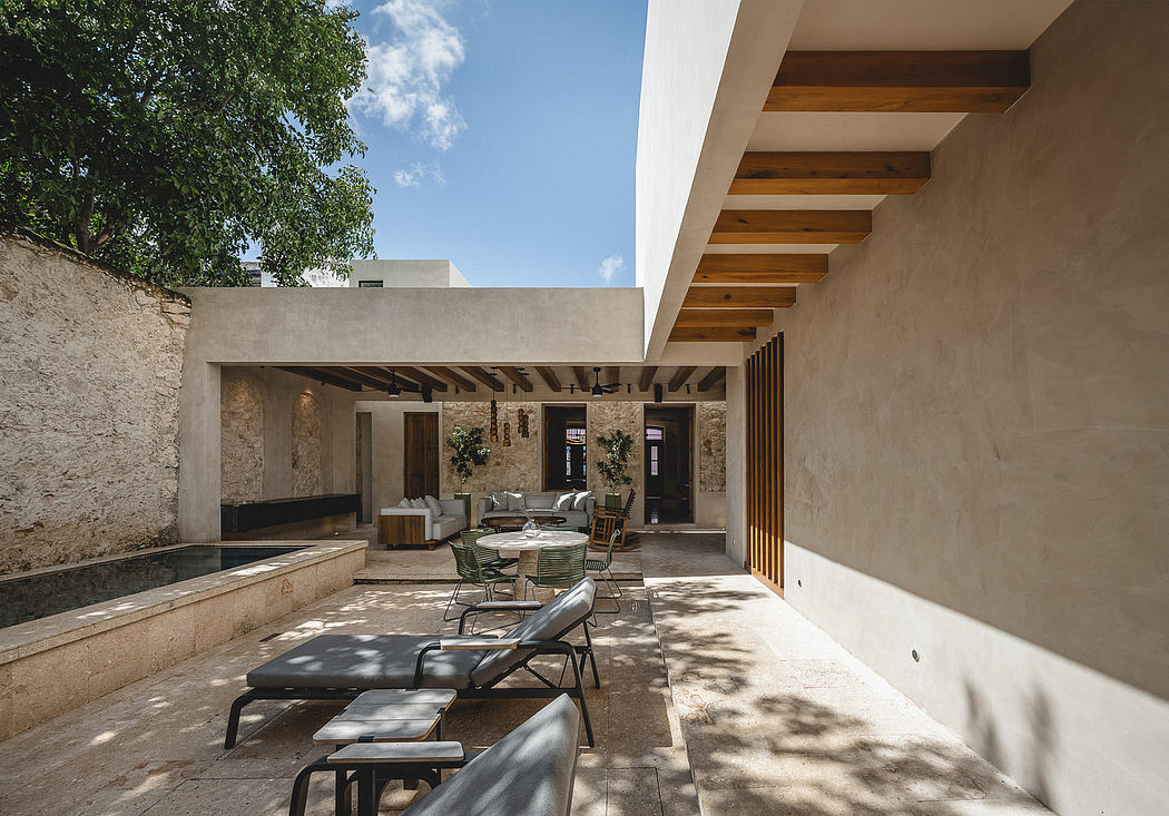 A modern patio with minimalist design, exposed wooden beams, and stone walls.