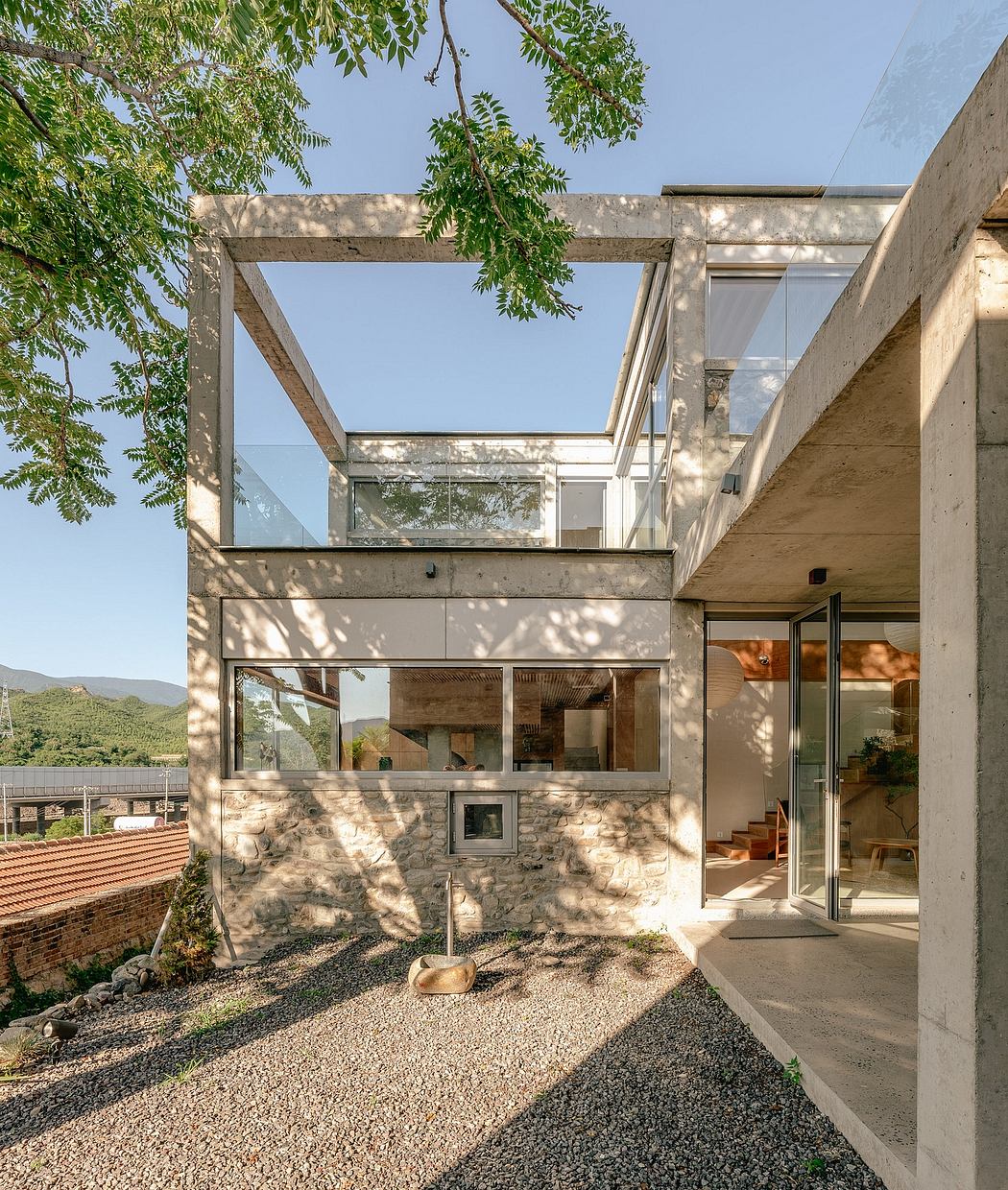 A modern, concrete and glass structure with a partially covered outdoor area.
