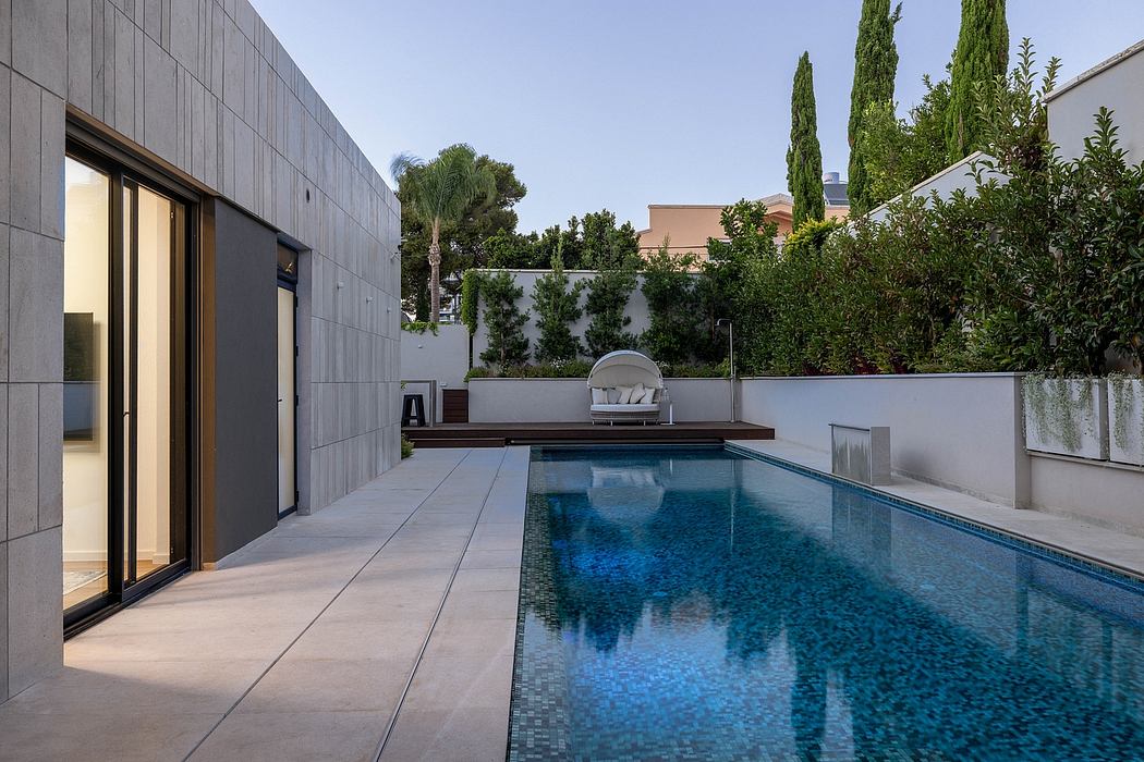 Modern architectural design with sleek exterior, outdoor pool, and lush greenery surrounding the property.