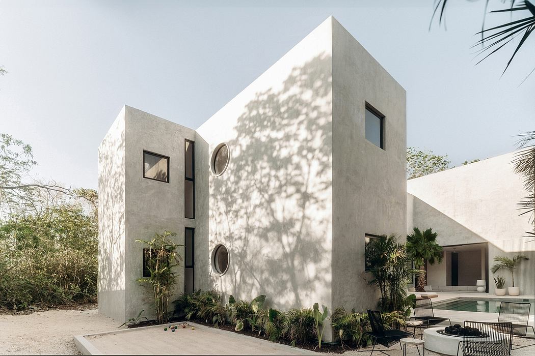 Striking modern architecture with geometric forms, concrete walls, and lush tropical landscaping.
