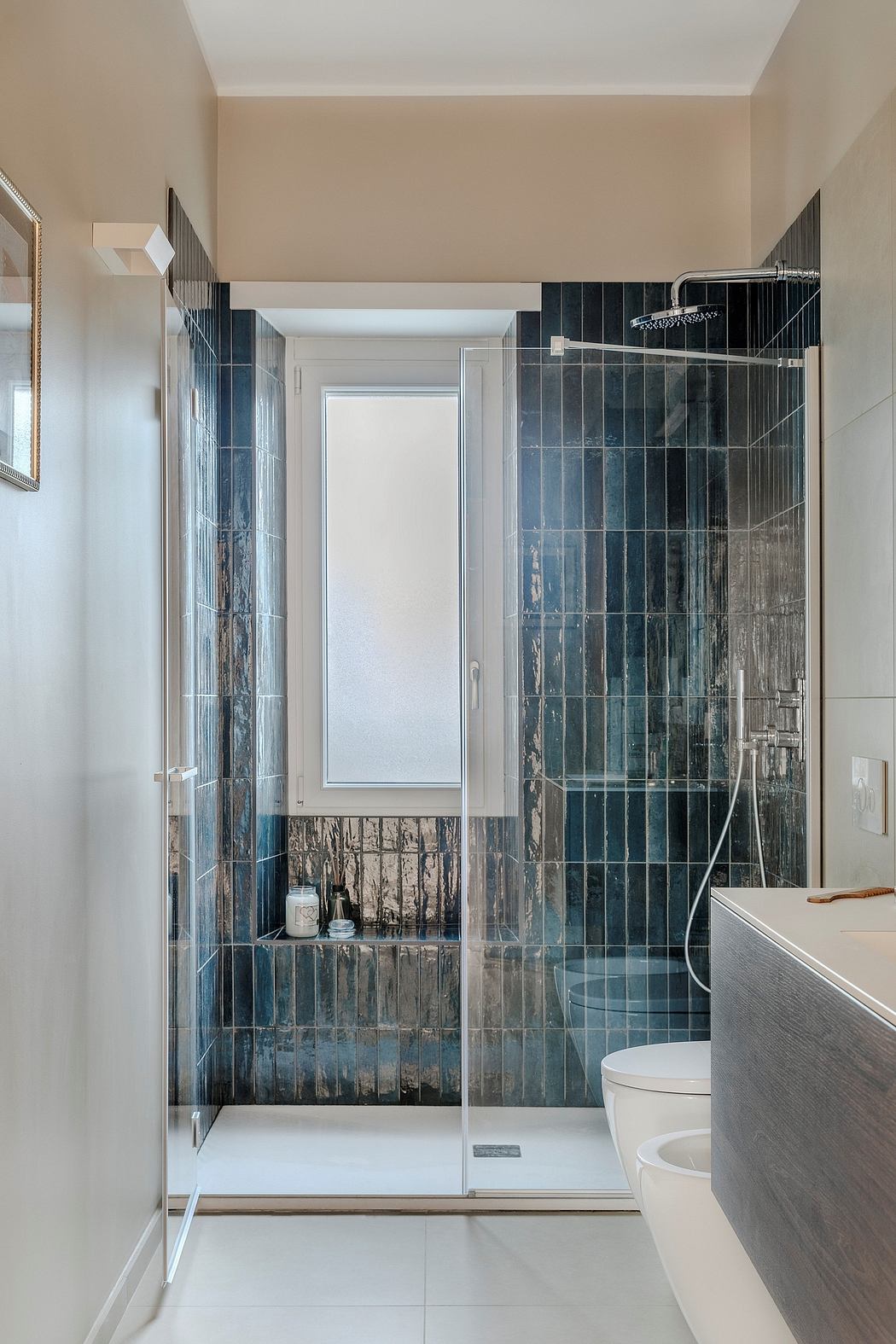 A modern bathroom with a sleek glass shower enclosure and textured tile walls.
