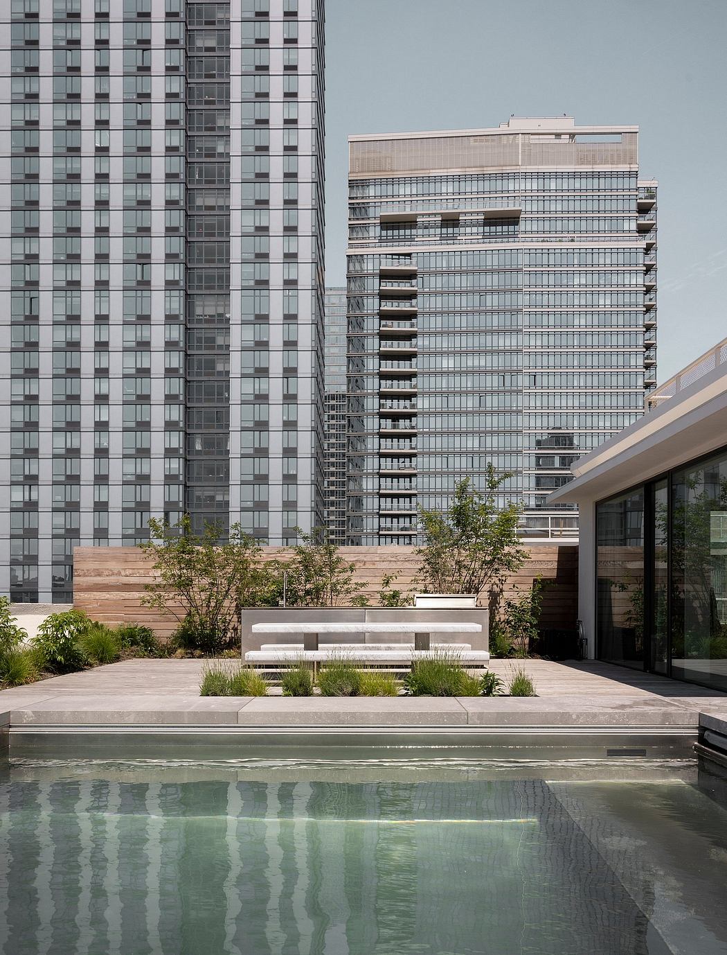 Sleek, modern architecture with reflective pools, lush vegetation, and minimalist seating.