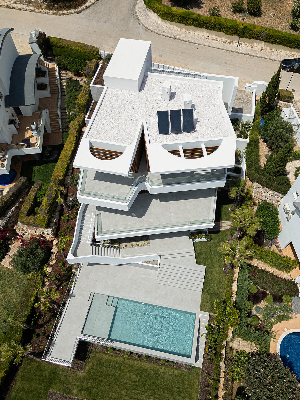 Striking modern architecture with asymmetrical design, large windows, and a swimming pool.