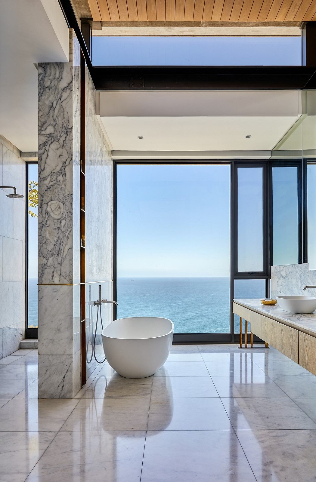 Sleek and sophisticated bathroom with marble accents and panoramic ocean view.