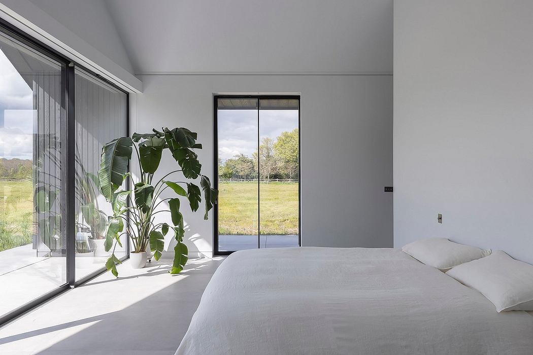 Minimalist bedroom design with large windows offering scenic outdoor views.