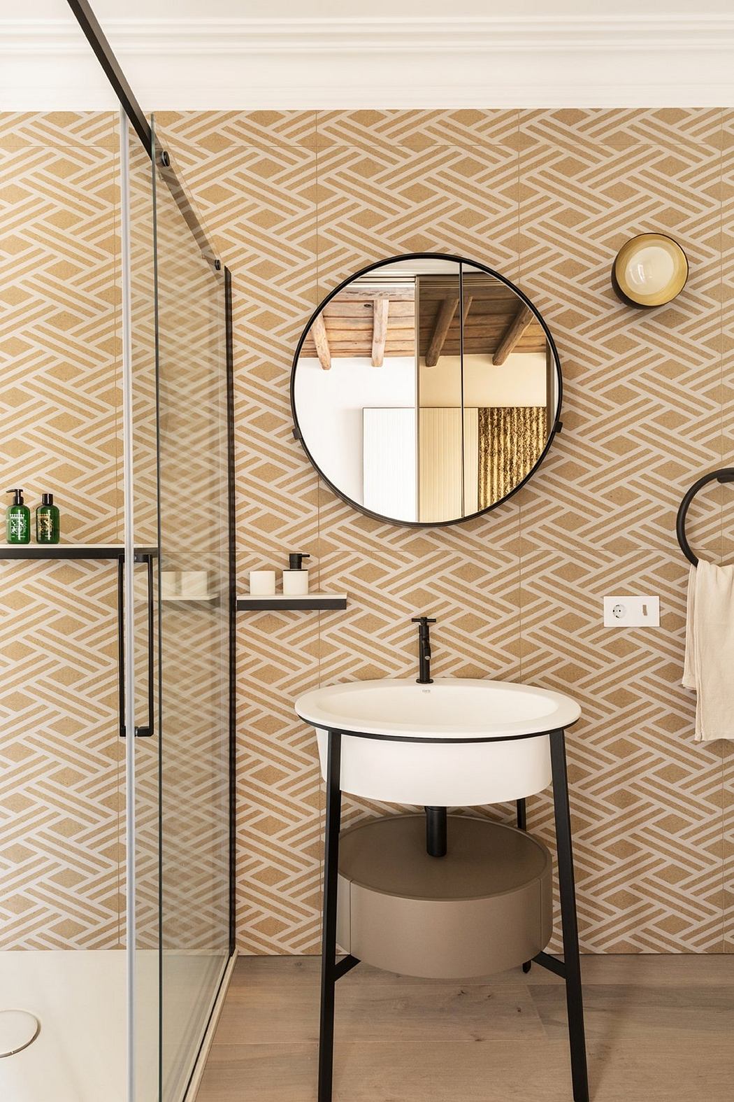 A modern bathroom with geometric patterned tiles, a round mirror, and minimalist fixtures.