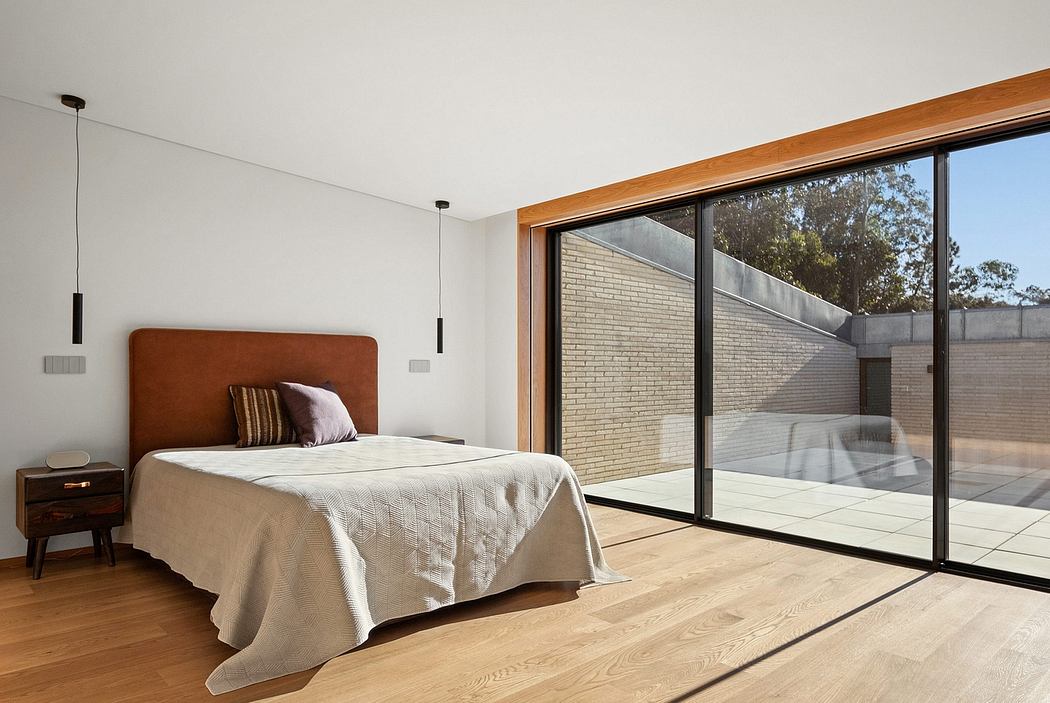Spacious modern bedroom with floor-to-ceiling windows, wood-framed bed, and hardwood floors.