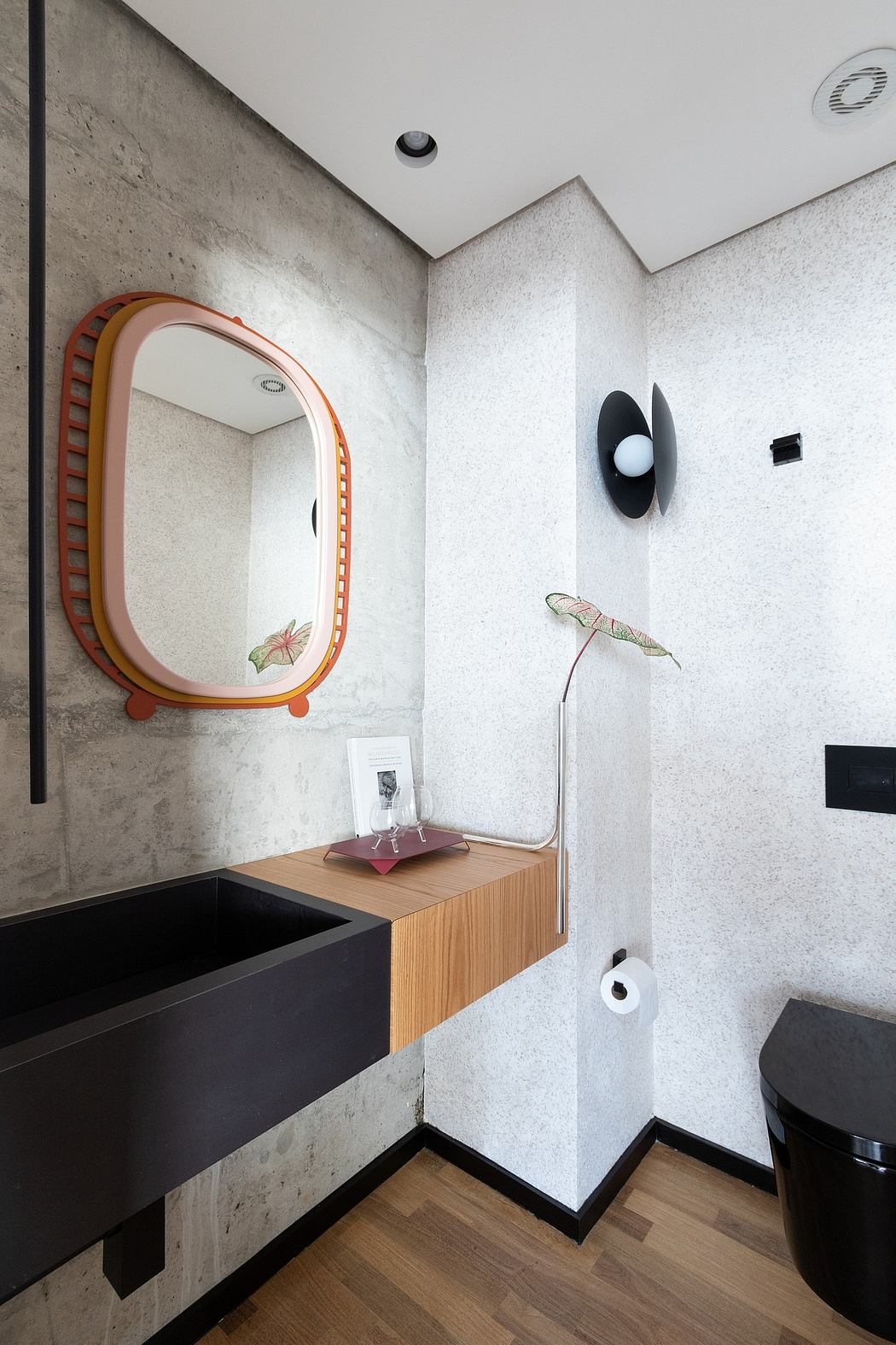 Modern bathroom with distinctive mirror, wall decor, and minimalist vanity.