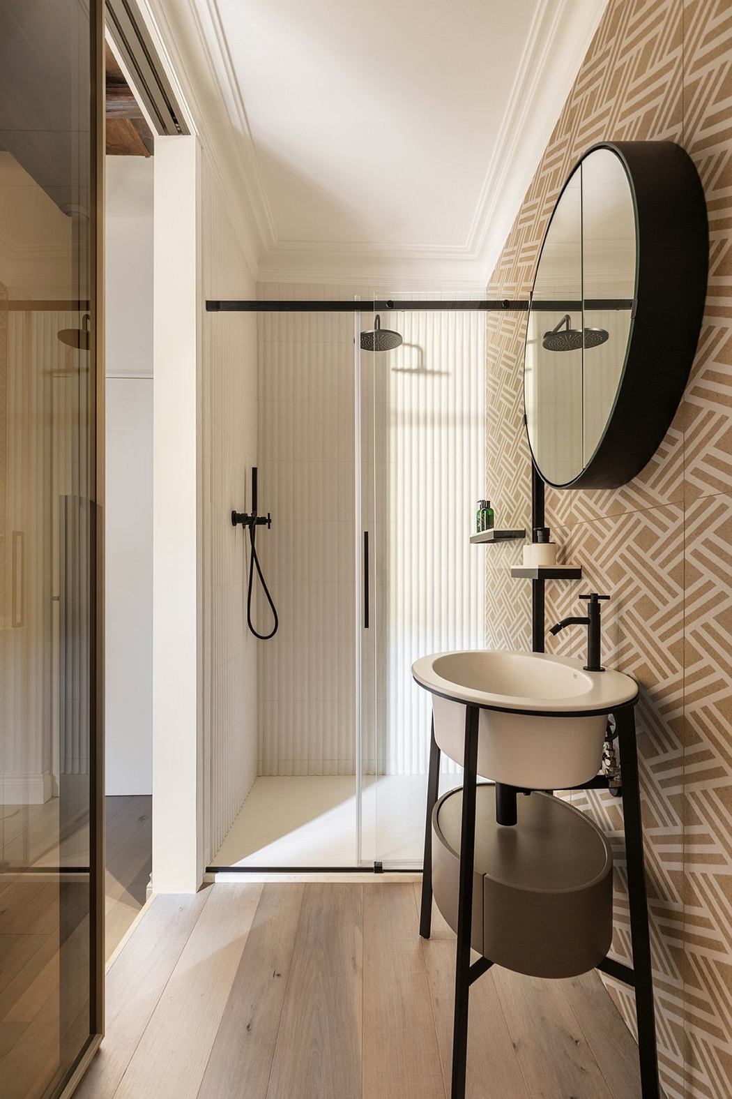 Stylish modern bathroom with sleek black fixtures, geometric wall patterns, and a circular mirror.