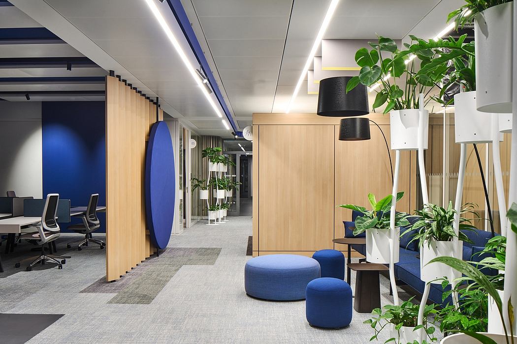 Spacious, modern office with wood accents, blue furnishings, and lush greenery.