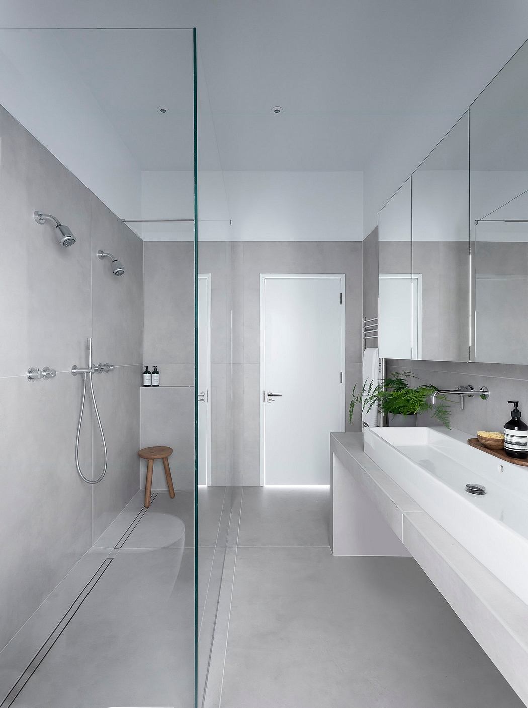 Minimalist bathroom design with glass shower, floating vanity, and neutral palette.