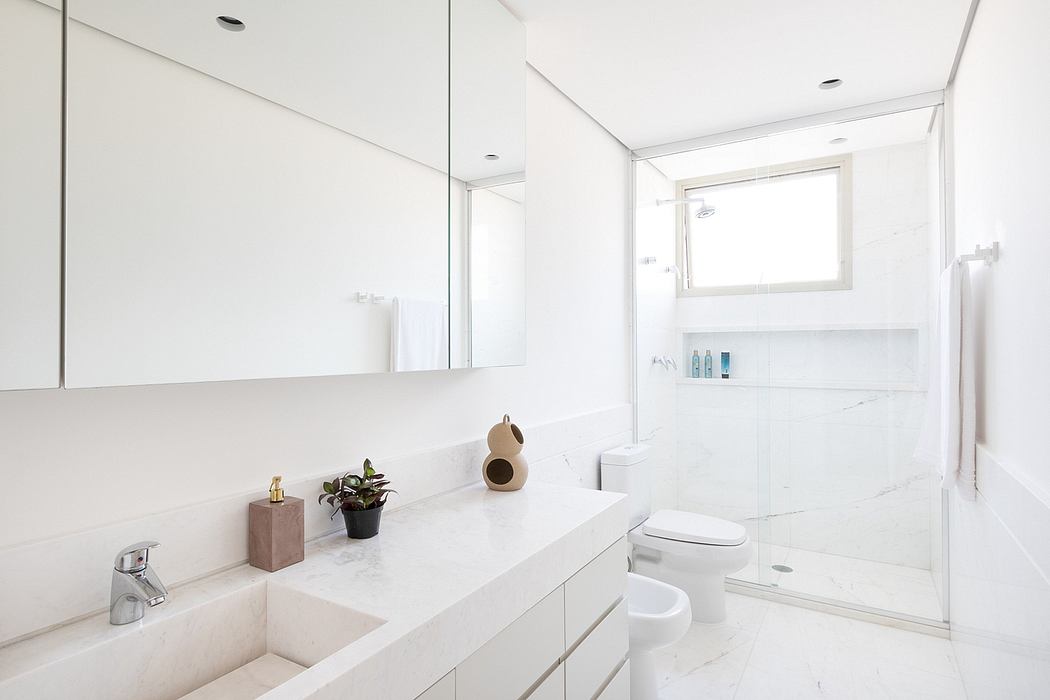 Sleek, minimalist bathroom design with clean lines, white marble, and recessed lighting.