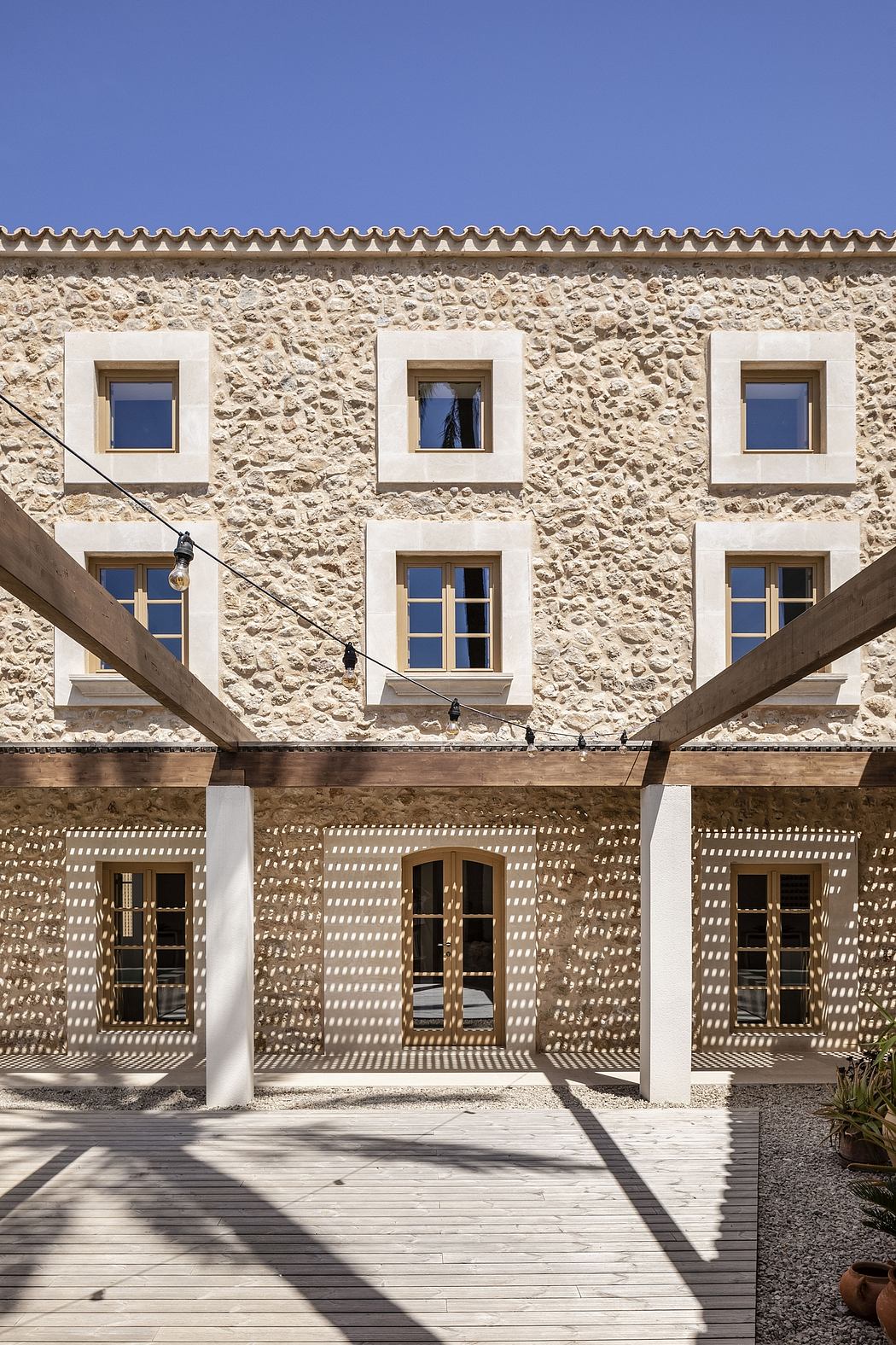 A stone facade with ornate windows and a wooden deck, creating an inviting outdoor space.