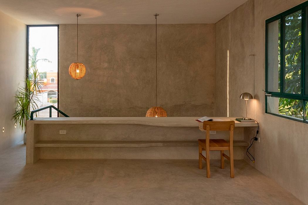 Warm, minimalist interior with concrete walls, wooden desk, and pendant lights.