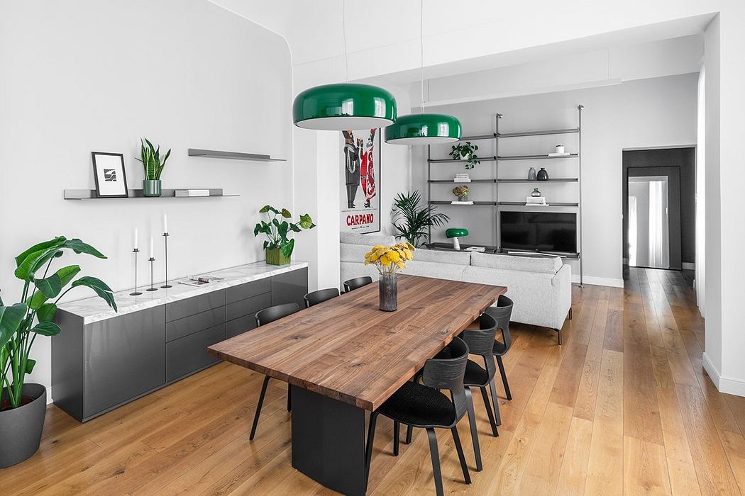 Minimalist dining room with sleek wooden table, black chairs, and modern hanging lamps.