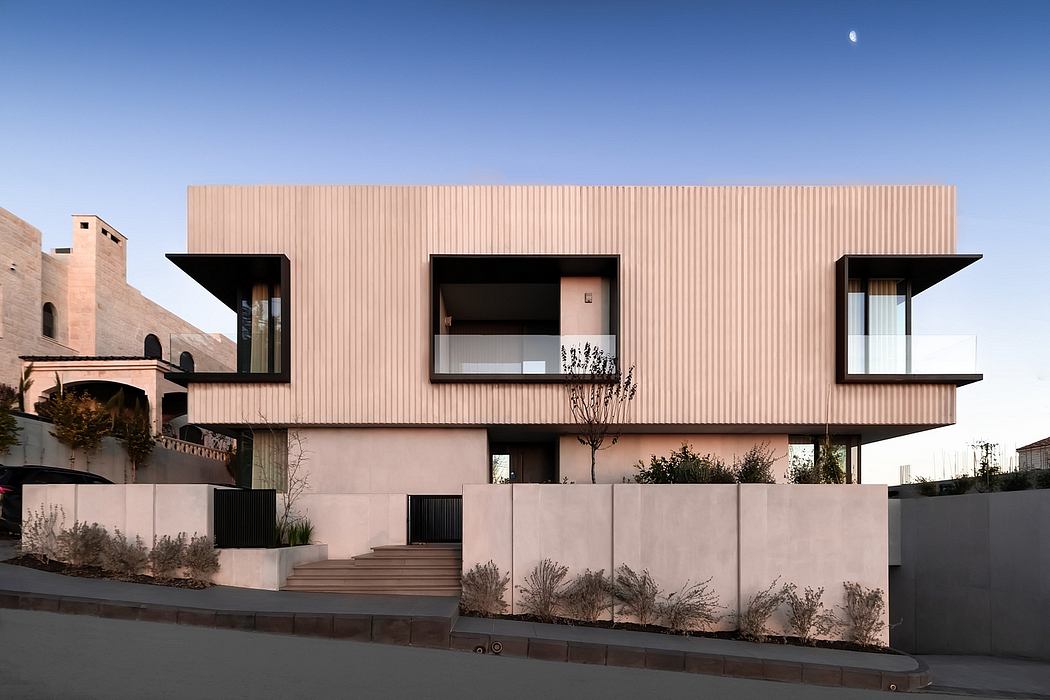 Modern building with pink paneled exterior, large windows, and tiered roofline.
