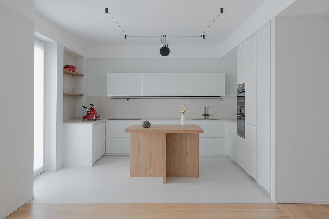 Minimalist kitchen design with sleek white cabinets, wood island, and track lighting.