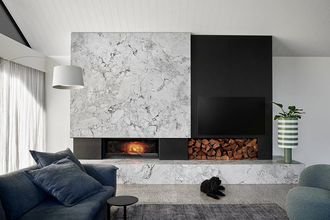 Minimalist living room with sleek marble fireplace and built-in firewood storage.