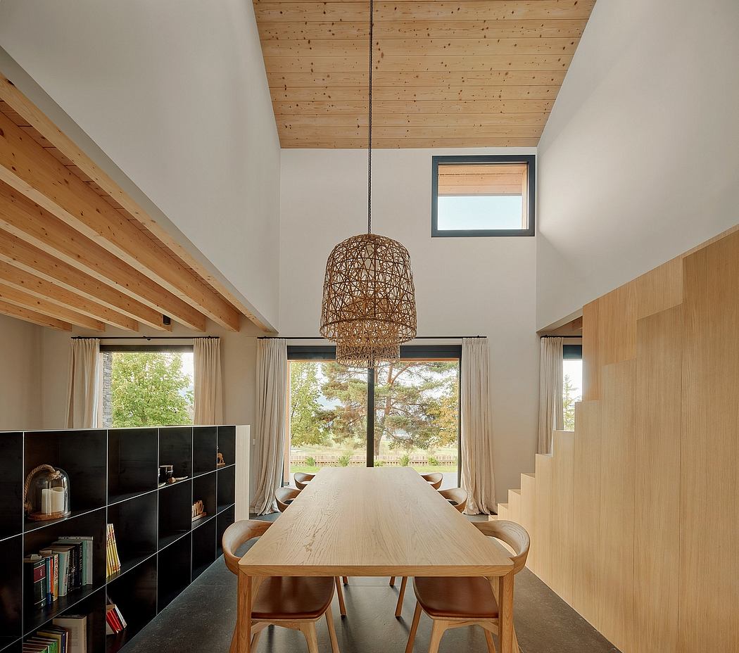 Spacious dining room with wooden beamed ceiling, large table, and woven pendant light.
