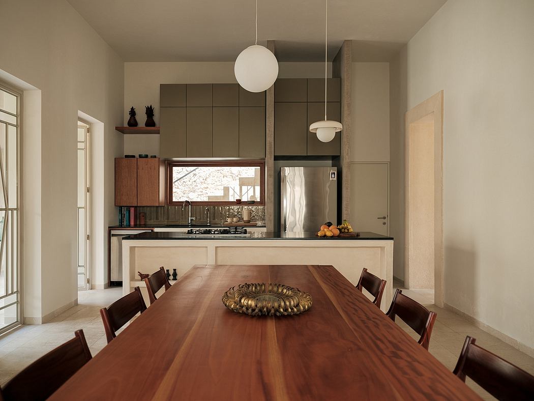 Spacious, modern kitchen with wooden dining table and globe pendant lights.