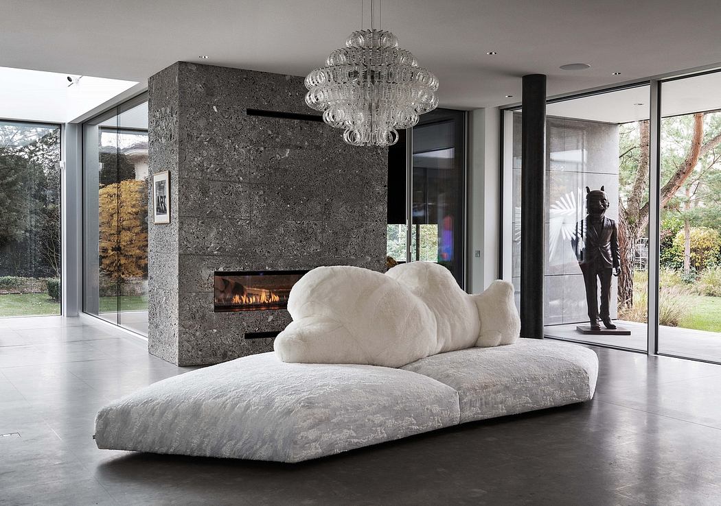 Modern luxurious living room with sleek stone fireplace, plush white couch, and a striking crystal chandelier.