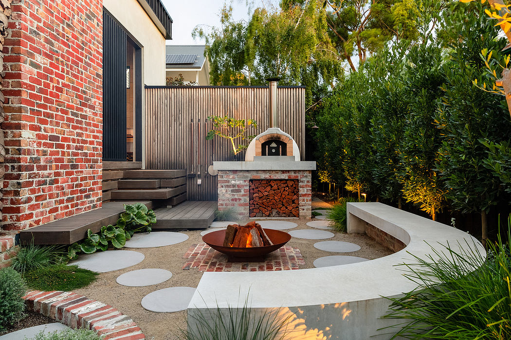 A brick-walled home with a wood-fired pizza oven, sunken seating area, and lush landscaping.