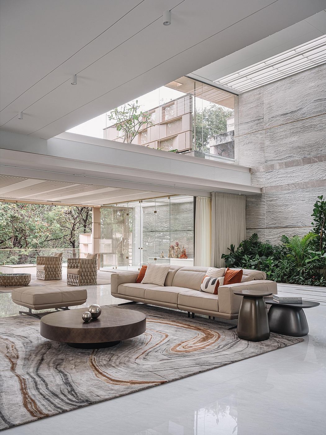 Sleek, modern living room with glass walls, stone accents, and a stylish rug.