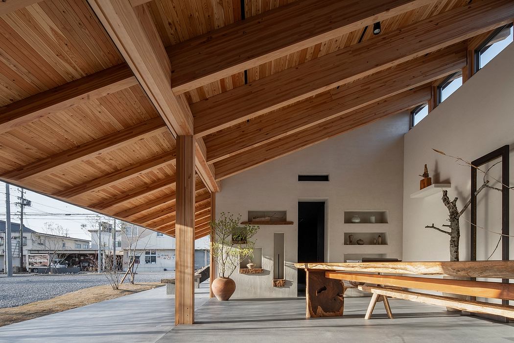 Rustic wooden beams, modern shelving, and a natural wood table create a harmonious interior.