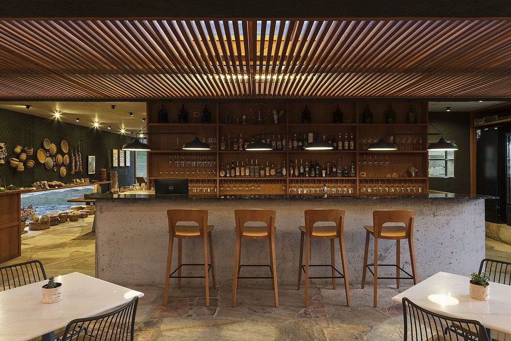A cozy and inviting bar with warm wooden accents, a concrete bar, and stylish barstools.