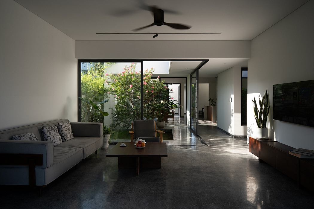 Spacious modern living room with sleek furniture, large windows, and an indoor garden.